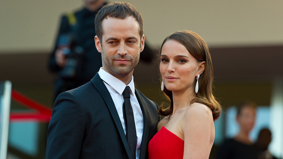 Benjamin Millepied and Natalie Portman smile for a photo on a red carpet
