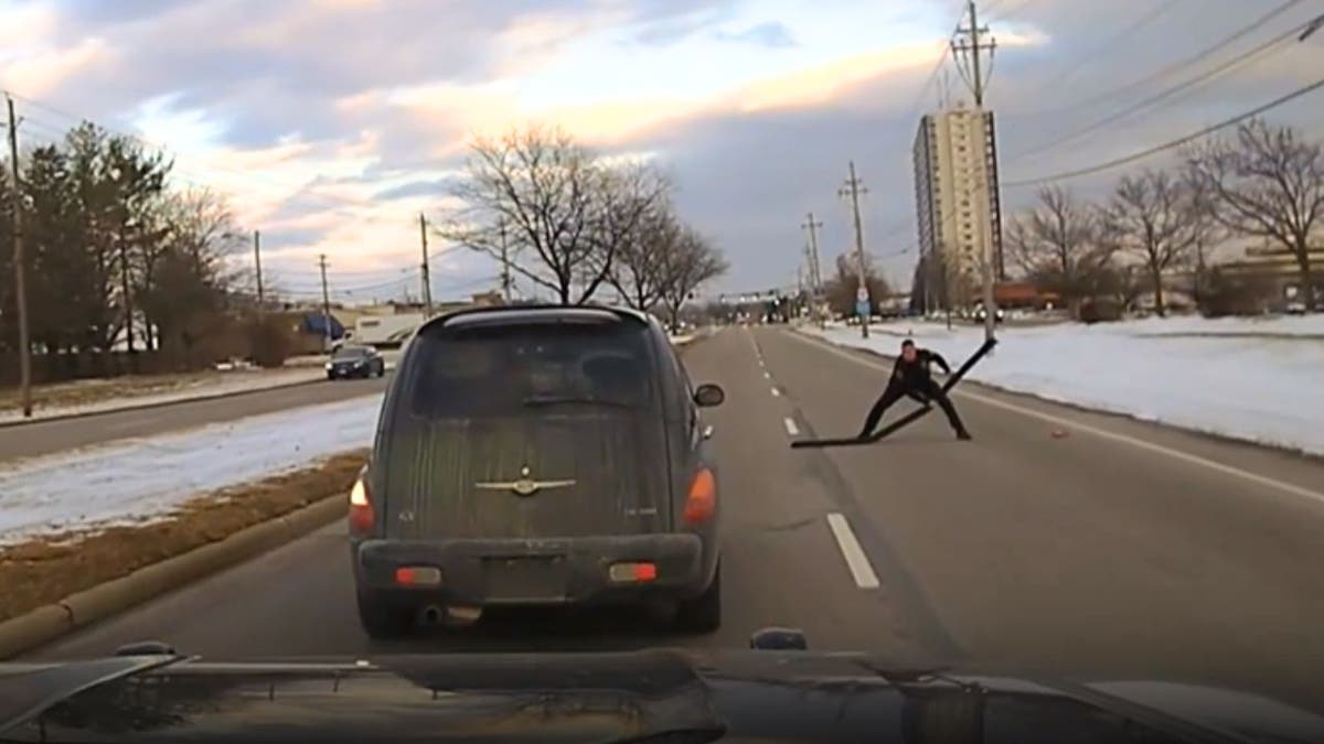 An image of a police officer throwing spikes on the road to slow down a vehicle