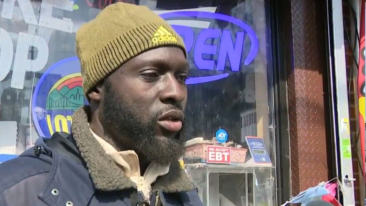A man being interviewed after his store was found to be housing migrants