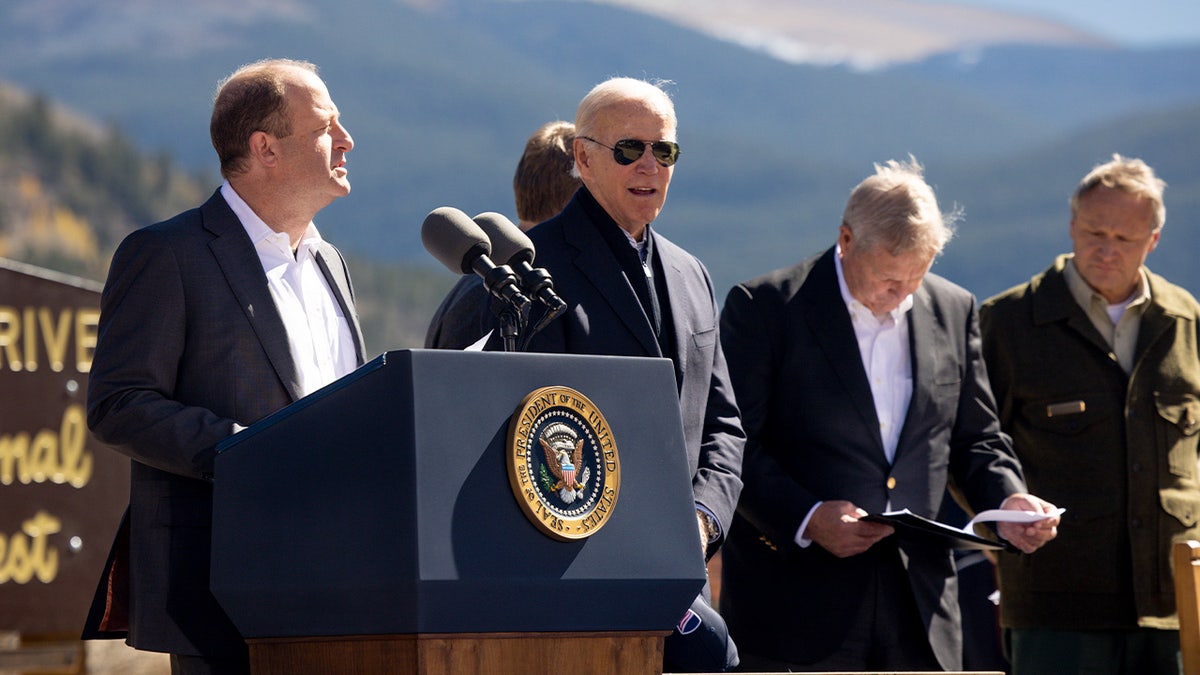 Colorado governor Jared Polis (L) speaks at Camp Hale while standing with U.S. President Joe Biden, Sen. Michael Bennett (D-CO), and U.S. Secretary of Agriculture Tom Vilsack before Biden designates the area as a national monument on October 12, 2022 in Red Cliff, Colorado. Camp Hale, a World War II training ground for the 10th Mountain Division, is the first national monument that Biden has designated during his term as president. (Photo by Michael Ciaglo/Getty Images)