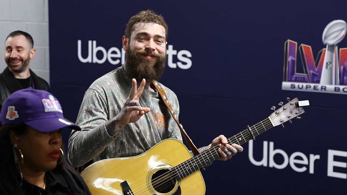 Post Malone walking with a guitar