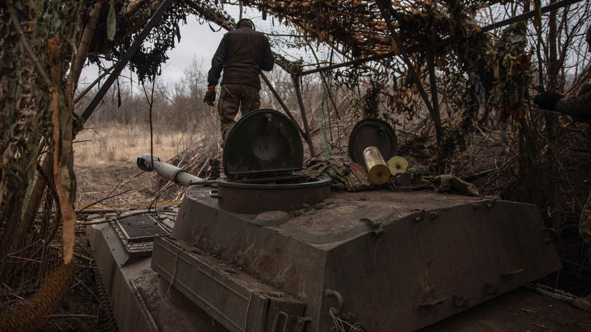 Ukrainian soldiers on the front lines point an artillery vehicle at Russia