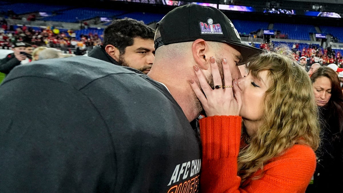 Travis Kelce and Taylor Swift kissing on the field