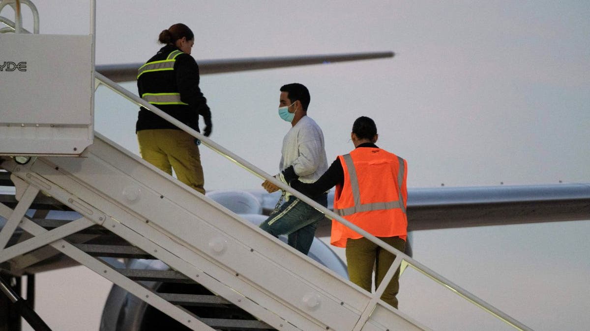 A man in shackles boards the first deportation flight of Venezuelans after a US-Venezuelan agreement 