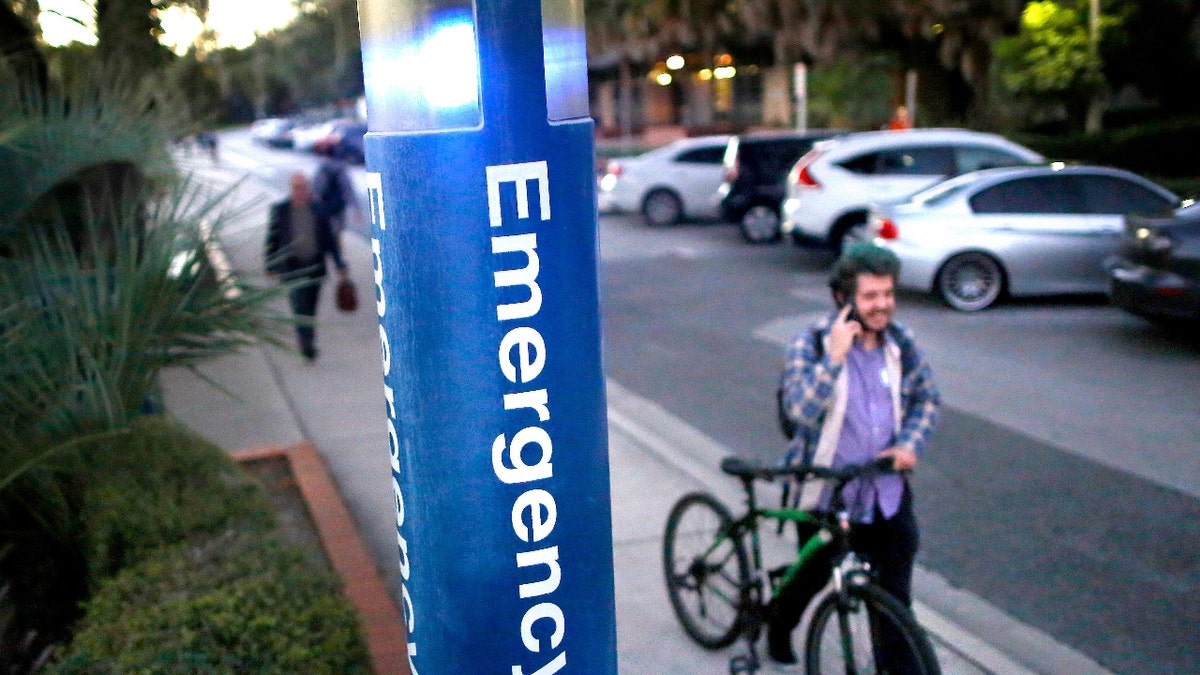 A photo of an emergency blue light near a sidewalk