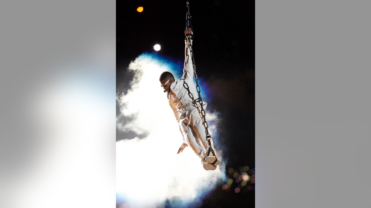 Usher segurando uma corda durante o show do intervalo do Super Bowl de 2011