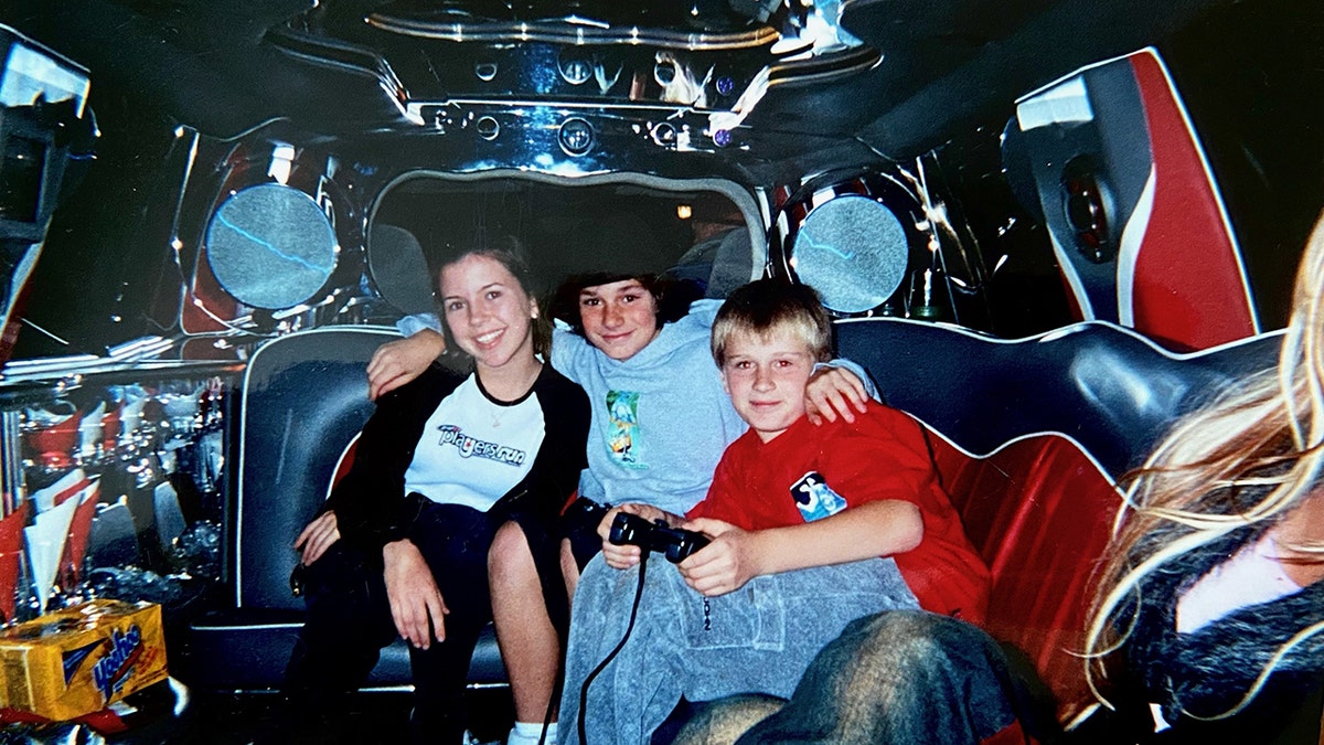 Lewis holding a game controller next to Cooper and a pal