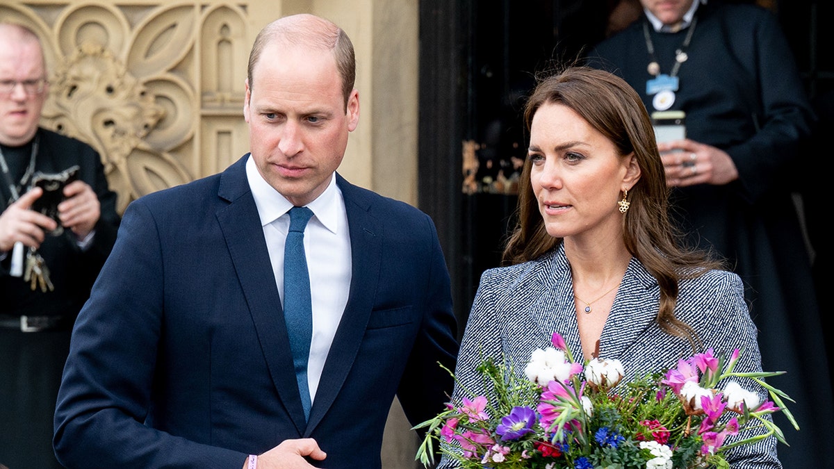 Kate Middleton hold a bouquet of flowers as Prince William looks serious