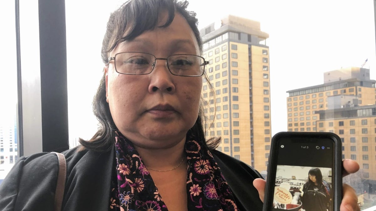 Homicide victim Veronica Abouchuk's sister shows a picture of her late sister outside the courtroom in 2019