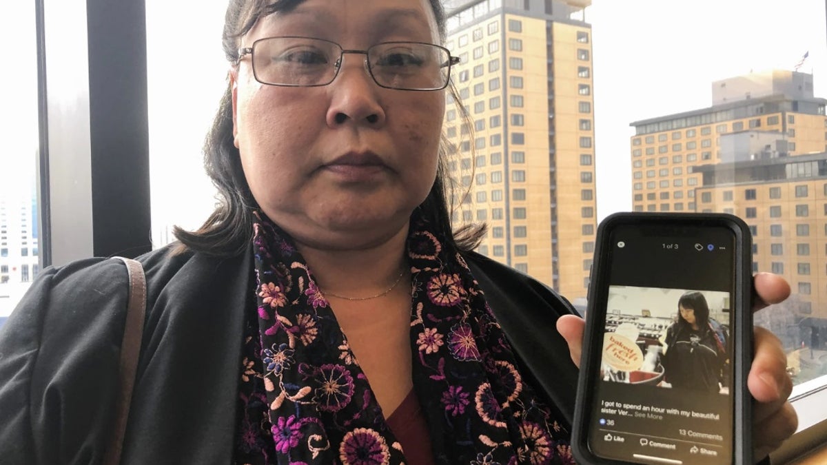 Homicide victim Veronica Abouchuk's sister shows a picture of her late sister outside the courtroom in 2019