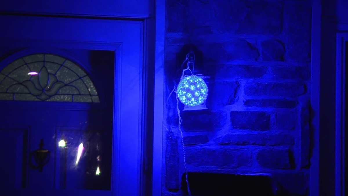 A home with a blue light installed by the front door