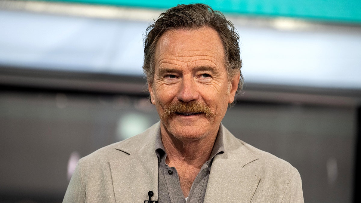 Bryan Cranston in a light grey/tan jacket sits at "TODAY"