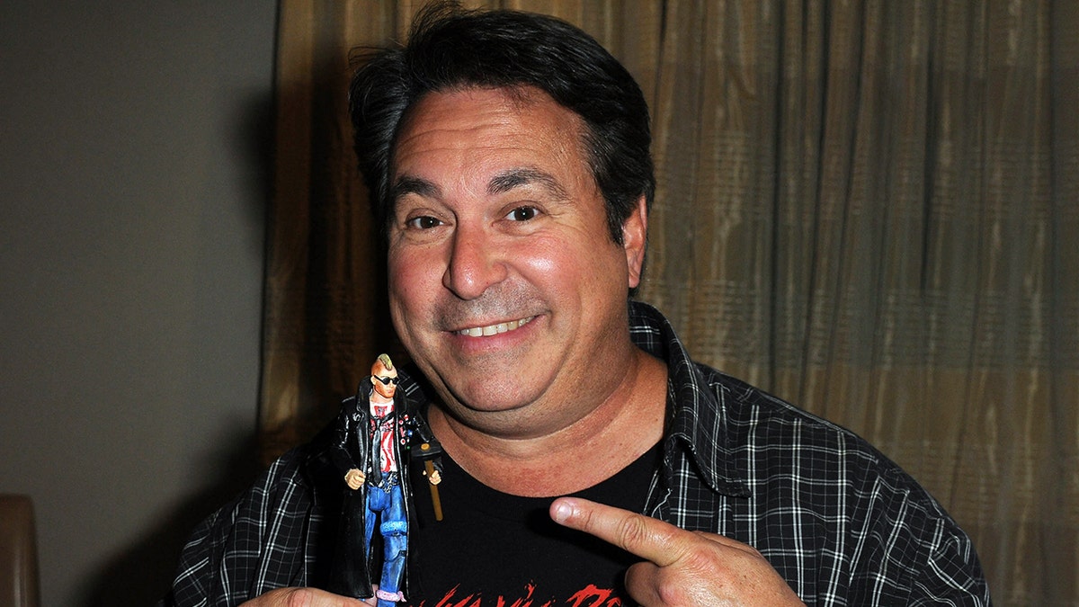Brian Peck segura uma boneca em convenção de quadrinhos