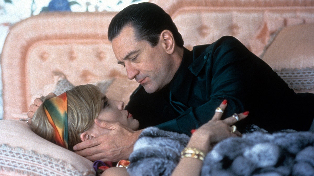 Sharon Stone lies down on a bed and is cradled by Robert De Niro in a scene from 'Casino'