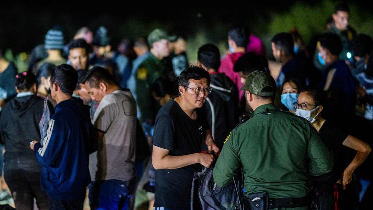 Border Patrol officer talks with Chinese migrant