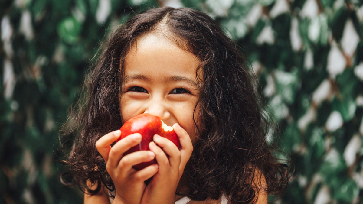 little girl eating an apple