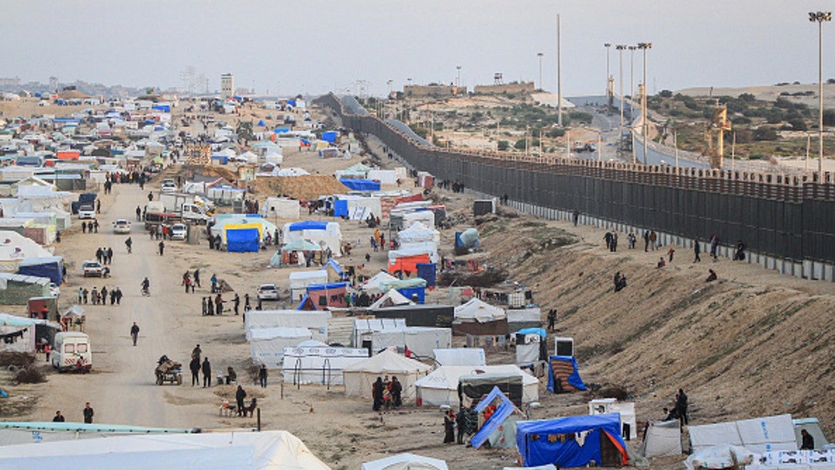 Tents and makeshift homes put up next to Egyptian border wall