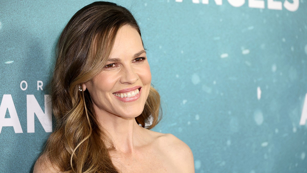 Hilary Swank smiles and slightly tilts her head on the carpet