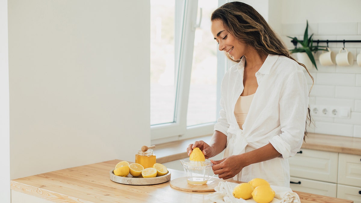 woman cuts lemon in a kitchen
