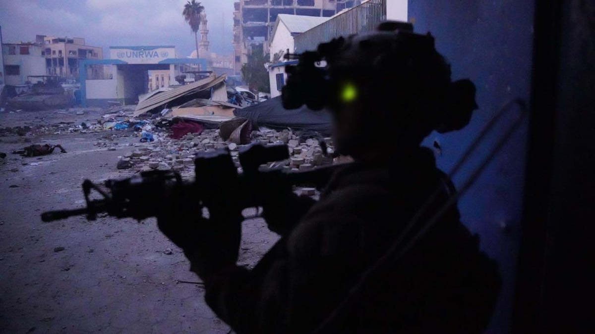 IDF soldier standing with gun near UNRWA building