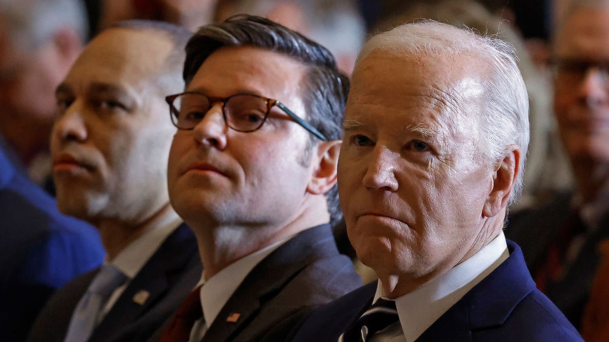 Mike Johnson sits next to Joe Biden during event