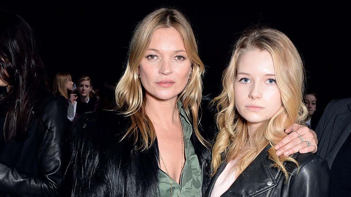Kate Moss wraps her arm around sister Lottie at a fashion show