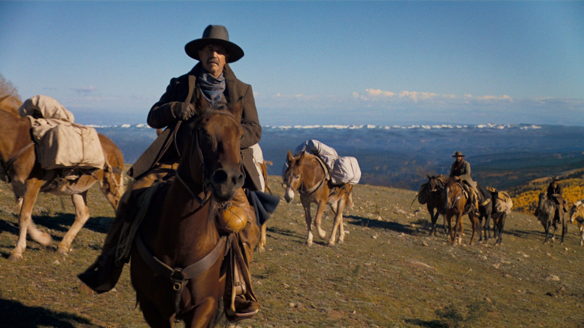 Kevin Costner lleva sombrero de vaquero mientras monta a caballo en la caravana Horizon