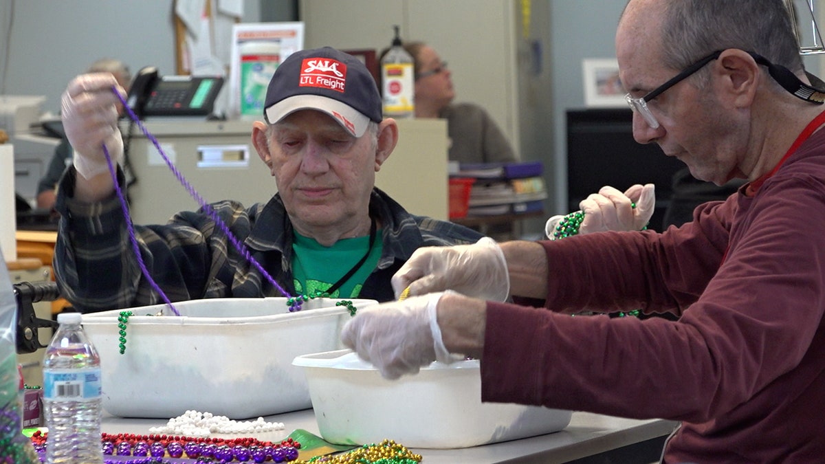 Lafourche Arc participants are sorting beads at a table from trays