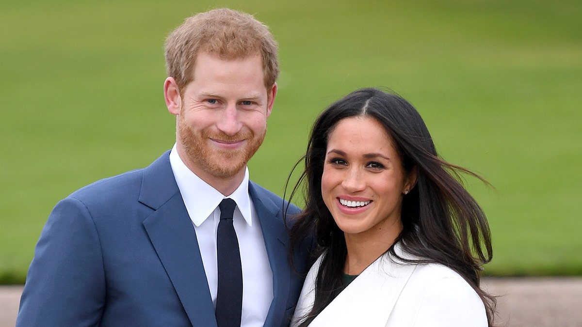 Príncipe Harry e Meghan Markle sorriem no Palácio de Kensington