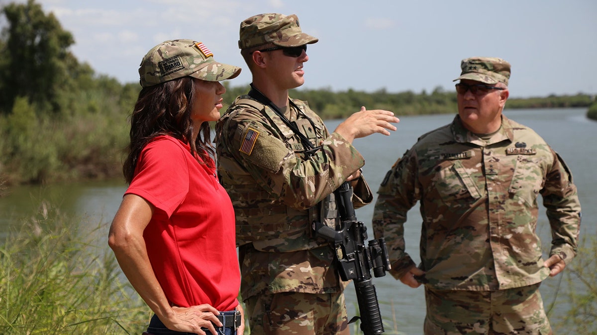 Gov. Kristi Noem poses with National Guard troops at the border in McAllen, Texas