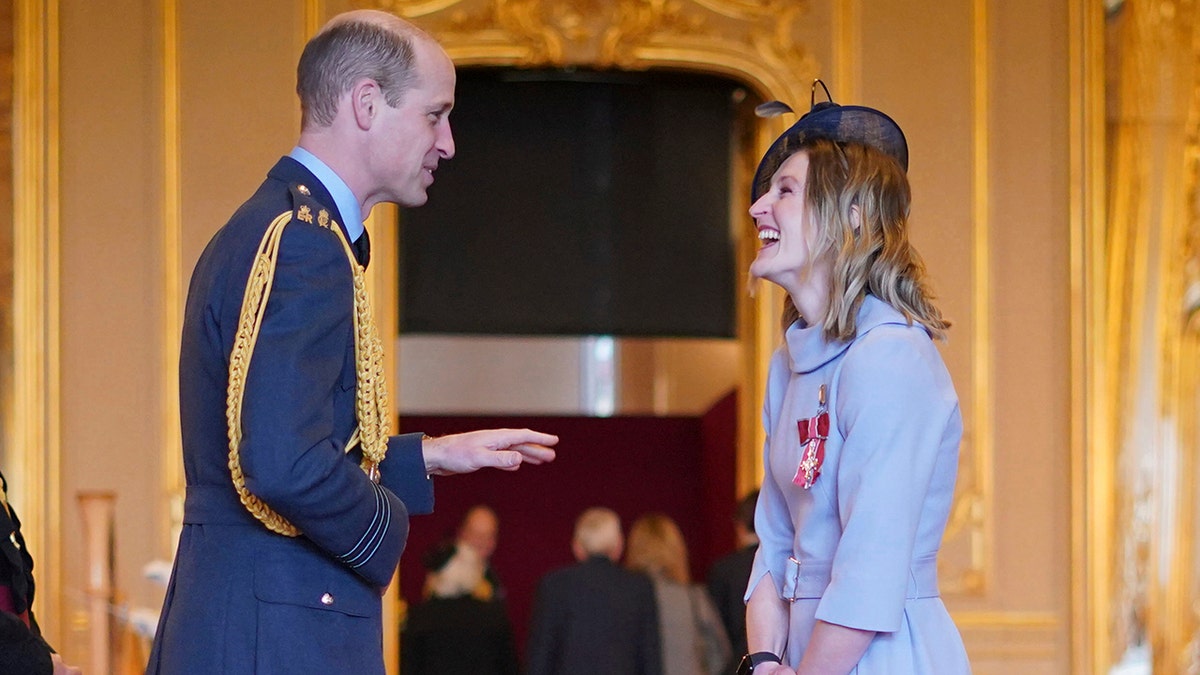 Prince William in his navy uniform smiles across from Ellen White at Windsor Castle