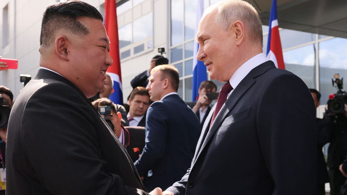 Russia's President Vladimir Putin (R) shakes hands with North Korea's leader Kim Jong Un (L)