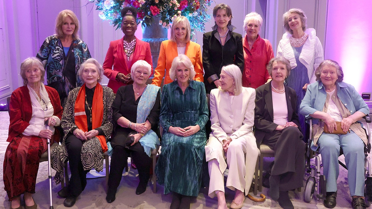 Queen Camilla in a dark green dress is surrounded by Dames including Judi Dench to her direct left