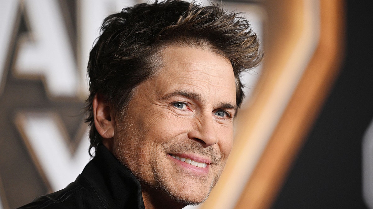 Rob Lowe Smiles on the carpet in a black shirt