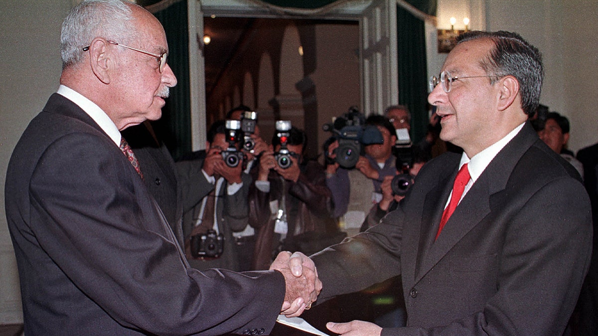 Bolivian President Hugo Banzer shakes hands pinch Victor Manuel Rocha