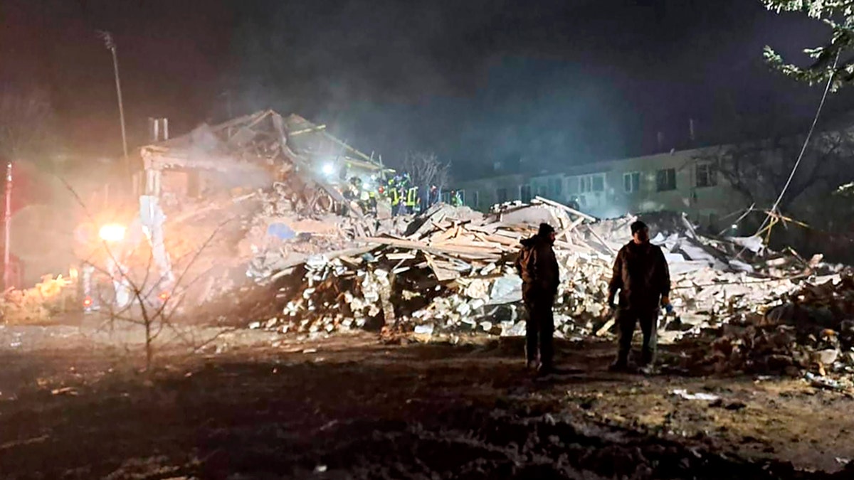 Firefighters looking at rubble