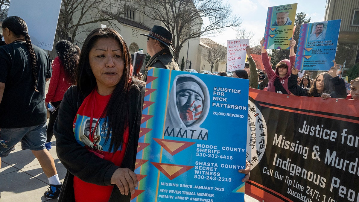 Woman marches with poster of missing brother