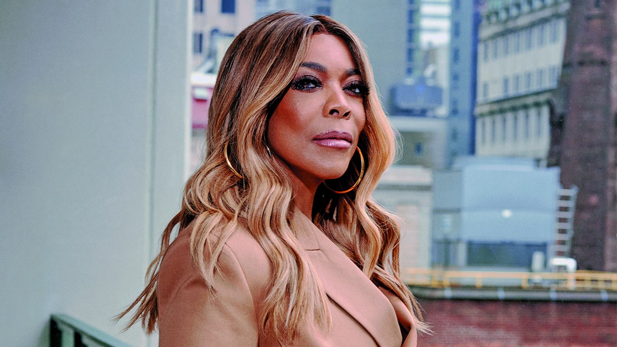 Wendy Williams poses for portrait photo wearing khaki trench coat