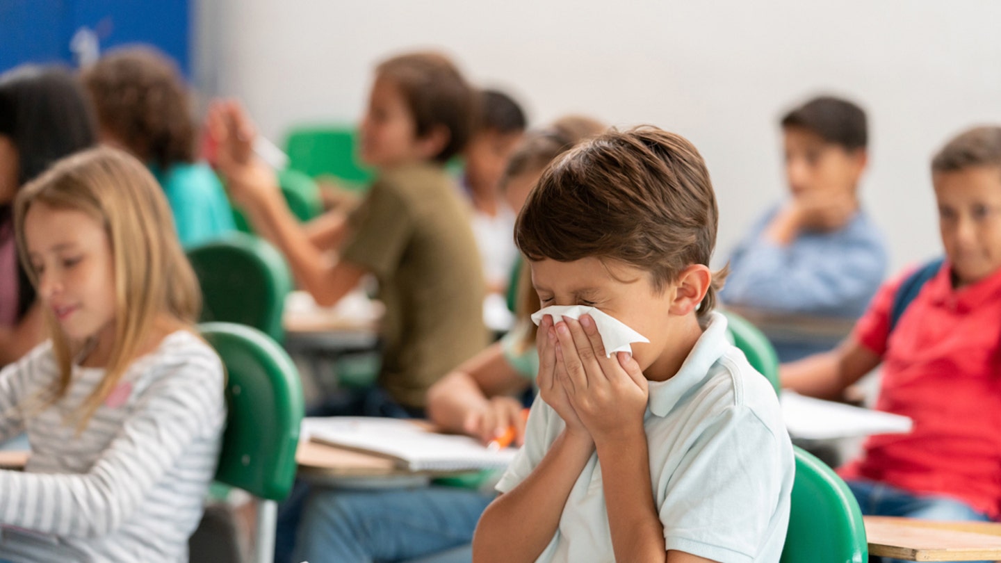 boy blowing nose in school