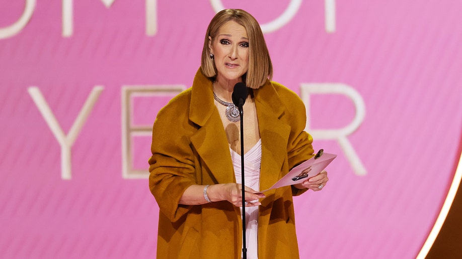 Celine Dion in a burnt orange coat on the Grammys stage presenting Album of The Year