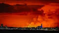 The skyline of Reykjavik is against the backdrop of orange coloured sky due to molten lava flowing out from a fissure on the Reykjanes peninsula north of the evacuated town of Grindavik, western Iceland on March 16, 2024.