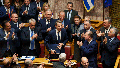 Greece Prime Minister Kyriakos Mitsotakis, center, is applauded by his partys lawmakers during a parliament session in Athens, Greece, Thursday, March 28, 2024. Greeces center-right government survived a motion of no-confidence late Thursday brought by opposition parties over its handling of the countrys deadliest rail disaster. Parliament voted 159-141 against the motion following an acrimonious three-day debate.