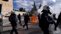 Riots police stand in front of the Parliament as a fire from a molotov cocktail is seen in the background during a students demonstration in Athens, Greece, Friday, March 8, 2024. Thousands of protesters have gathered in central Athens to oppose government plans to introduce privately-run universities, following weeks of demonstrations including scores of university building occupations by students. Lawmakers were to vote on the measure later Friday with the bill expected to pass. (