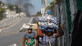 Street vendors run during clashes between police and gangs in Port-au-Prince, Haiti, Wednesday, March 6, 2024.