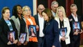 Family members hold portraits of the victims of the 2018 shooting at Marjory Stoneman Douglas High School as US Vice President Kamala Harris departs them after speaking about gun safety measures at the high school in Parkland, Florida, March 23, 2024.