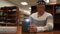 Minh Ha, assistive technology manager at the Perkins School for the Blind tries a LightSound device for the first time at the school's library in Watertown, Mass., on March 2, 2024. As eclipse watchers look to the skies in April 2024, new technology will allow people who are blind or visually impaired to hear and feel the celestial event.