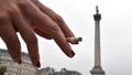 A woman holds her cigarette as she smokes in Trafalgar Square in central London October 15, 2014.