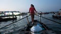 Nguyen Thi Thuy, a vendor who sells steamed buns on a floating market, paddles her boat in Can Tho, Vietnam, Wednesday, Jan. 17, 2024. On good days she makes about $4 &mdash; hardly enough to put food on the table.