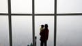 A woman holding her baby in her arms looks at a view of Seoul shrouded by fine dust during a polluted day in Seoul, South Korea, March 6, 2019.