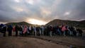 FILE - Asylum-seeking migrants line up in a makeshift, mountainous campsite to be processed after crossing the border with Mexico, Friday, Feb. 2, 2024, near Jacumba Hot Springs, Calif. The arrest of a Venezuelan man who entered the U.S. illegally for the murder of a 22-year-old nursing student in Georgia has triggered fiery reactions from Donald Trump and his allies. Trump blamed President Joe Biden and his immigration policies for the fatal beating of 22-year-old Laken Riley while on her morning run. (AP Photo/Gregory Bull, File) - Fox News